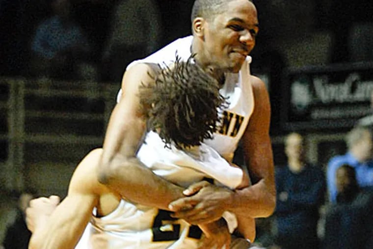 Neumann's Ja'Quann Newton (top) hugs teammate Derrick Stewart after the big win. (Ron Tarver / Staff Photographer)