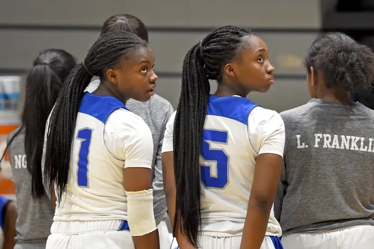 Sterling High School sisters Nia Holloway (left) and Imani Holloway (right) check the scoreboard during a timeout during a game on their home basketball court January 14, 2019.