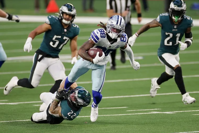 Eagles safety Marcus Epps (22) latches on to Dallas Cowboys wide receiver CeeDee Lamb on  Dec. 27. The Eagles lost, 37-17.