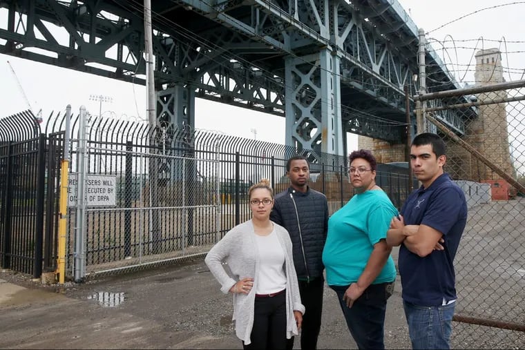 From left, North Camden residents Felisha Reyes Morton, Rudy M. Underdue, Jackie Santiago, and Luis Gaitan stand for a portrait outside the F.W. Winter building in Camden. They oppose the proposed erection of a 16-story digital billboard on the site by Interstate Outdoor Advertising.