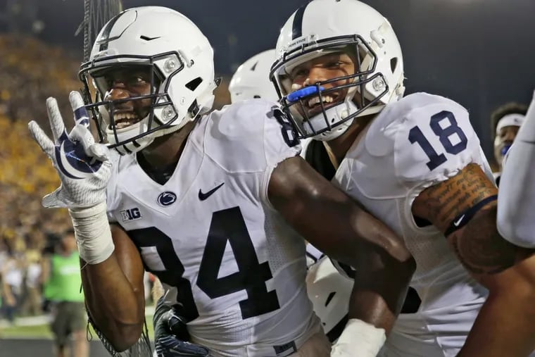 Penn State wide receiver Juwan Johnson, left, is congratulated by teammate Jonathan Holland after catching a touchdown pass as time expired to defeat Iowa.