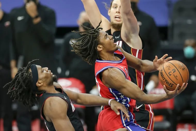 The Sixers' Tyrese Maxey goes up between the Heat's Precious Achiuwa, left and Kelly Olynyk during the third quarter.