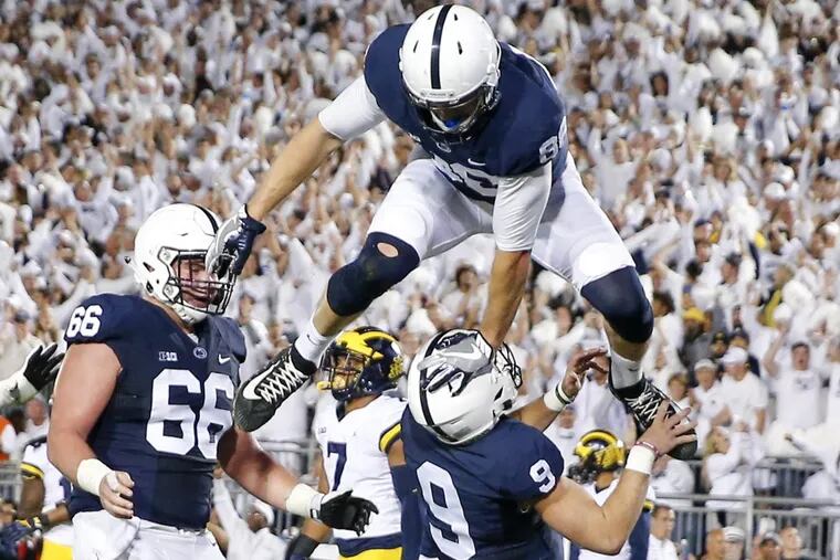Penn State tight end Mike Gesicki leaps over quarterback Trace McSorley after McSorley ran for a touchdown against Michigan as offensive lineman Connor McGovern looks on.