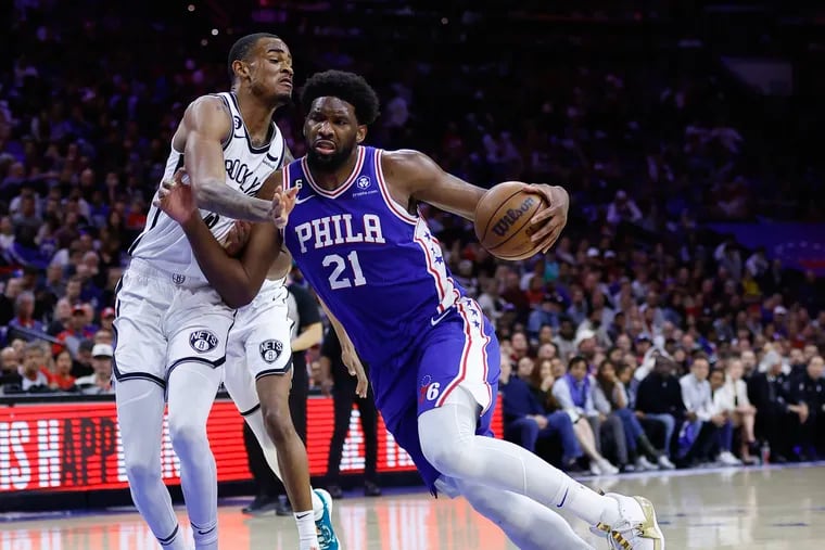 Sixers center Joel Embiid dribbles the basketball against Brooklyn Nets center Nic Claxton during Game 2 of the first round Eastern Conference playoffs on Monday.