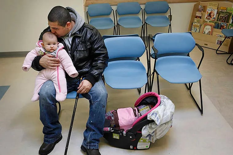 Ramon Rosado and daughter Eliana wait to be seen at the Esperanza Health Center.