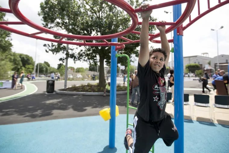 Elvis Berrocal, 12, plays on the monkey bars after the ribbon cutting ceremony at Jose Manuel Callazo Playground June 19, 2017. The Trust for Public Land  supported the city and Philadelphia School District in an effort to create public green spaces in areas where they were more than a 10-minute walk away, an effort that was started under Mayor Nutter.