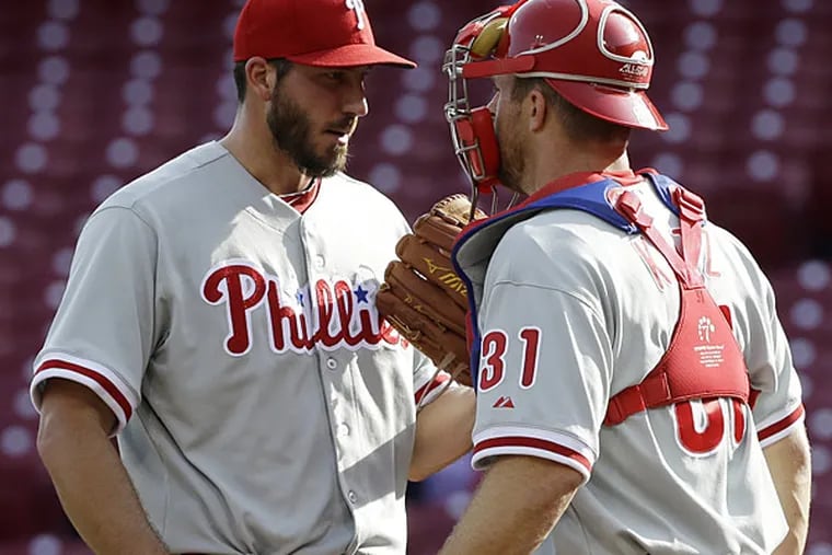 Phillies relief pitcher Phillippe Aumont talks with catcher Erik Kratz (31) in the bottom of the ninth inning of a baseball game against the Cincinnati Reds, Wednesday, April 17, 2013, in Cincinnati. (Al Behrman/AP)