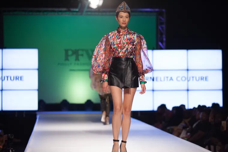 Model wears a leather skirt and floral blouse from local designer Carmelita Couture on a past Philly Fashion Week runway.