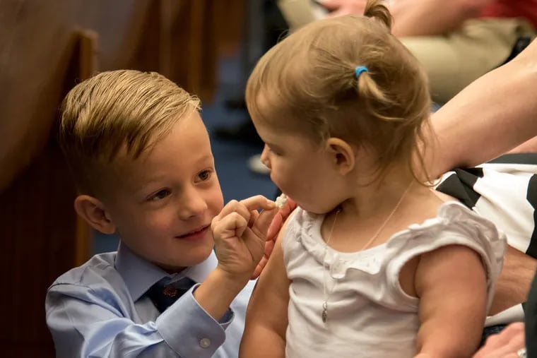 Dominic Masciantonio, 5, offers his little sister Gianna, 19 months, some of his cereal snack inside the ceremonial courtroom at the federal courthouse in Philadelphia on May 31, 2016, where he was installed as an honorary U.S. marshal for protecting his sister, who is fighting a brain tumor. Gianna was kissed and blessed by Pope Francis during the papal visit last fall.