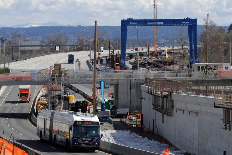 A bus drives past a roadwork construction project in Seattle where ramps off of the Highway 520 floating bridge meet Montlake Blvd. that has been shut down due to concern over the spread of the coronavirus.