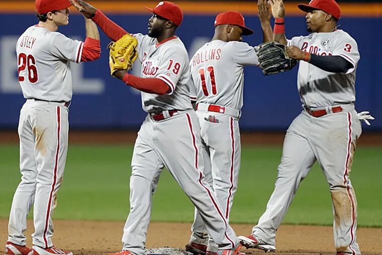Chase Utley (26), Tony Gwynn (19), Jimmy Rollins (11) and Marlon Byrd (3) celebrate after a baseball game against the New York Mets, Friday, May 9, 2014, in New York. The Phillies won 3-2. (Frank Franklin II/AP)