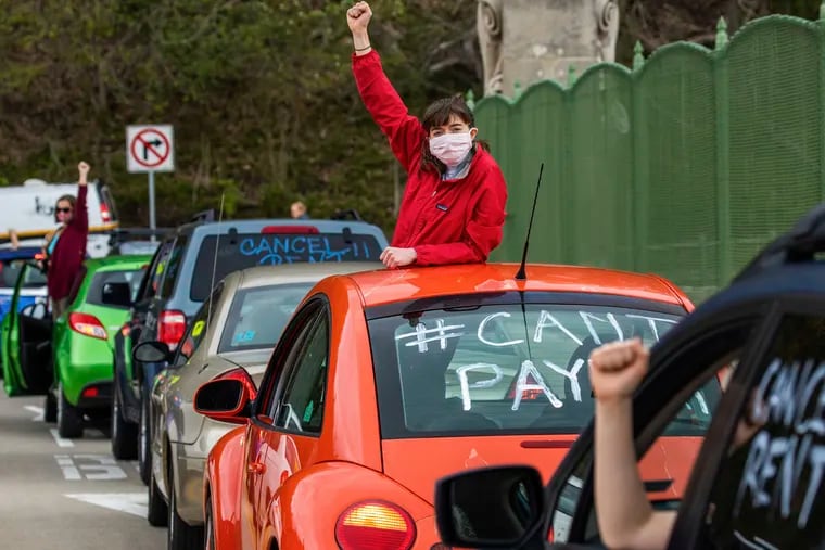 Georgia Burr, of Squirrel Hill, stands in her car as she and other protesters block a lane of the Greenfield Bridge in Pittsburgh during during a "Can't Pay May! Car Protest/Rally" on May 1. The protesters called for Pennsylvania and national leaders to enact rent and mortgage freezes.