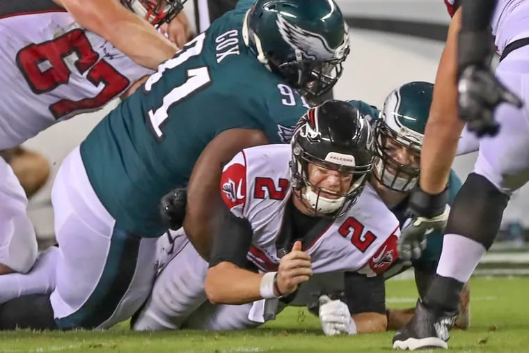 Atlanta's Matt Ryan is thrown to the ground by Eagles defensive tackle Fletcher Cox, left,  in the fourth quarter and forced him to fumble the ball, it was recovered  by the Falcons.