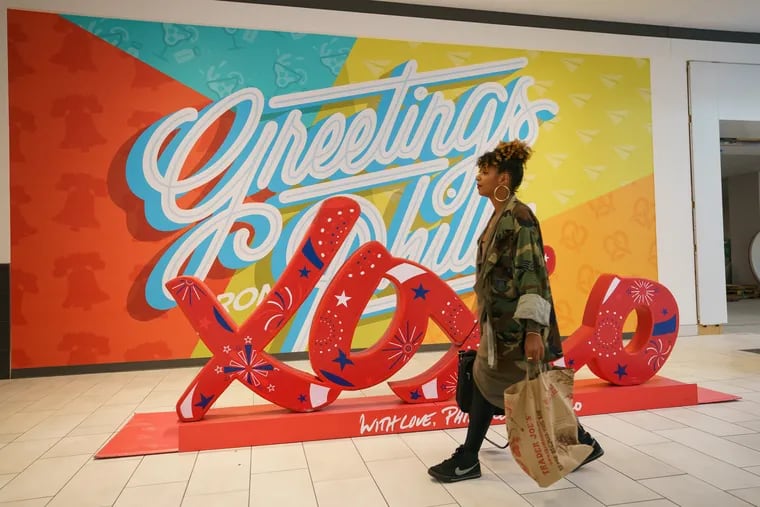 Shanti Mayers, owner of a boutique called The Sable Collective, walks past a sculpture and mural at the new Fashion District during a media preview of the new shopping and entertainment area located on Market Street near 9th Street, in Philadelphia, September 17, 2019.