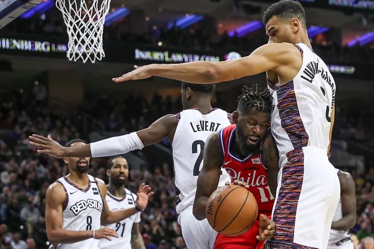 Sixers' James Ennis III grabs a rebound against the Brooklyn Nets' Timothé Luwawu-Cabarrot on Wednesday.
