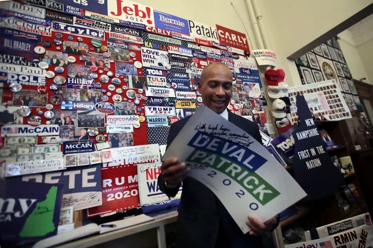 Democratic presidential candidate former Massachusetts Gov. Deval Patrick adds his campaign sign to pins, signs and bumper stickers of New Hampshire primary presidential contenders on display in the State House visitors center, Thursday, Nov. 14, 2019, in Concord, N.H.