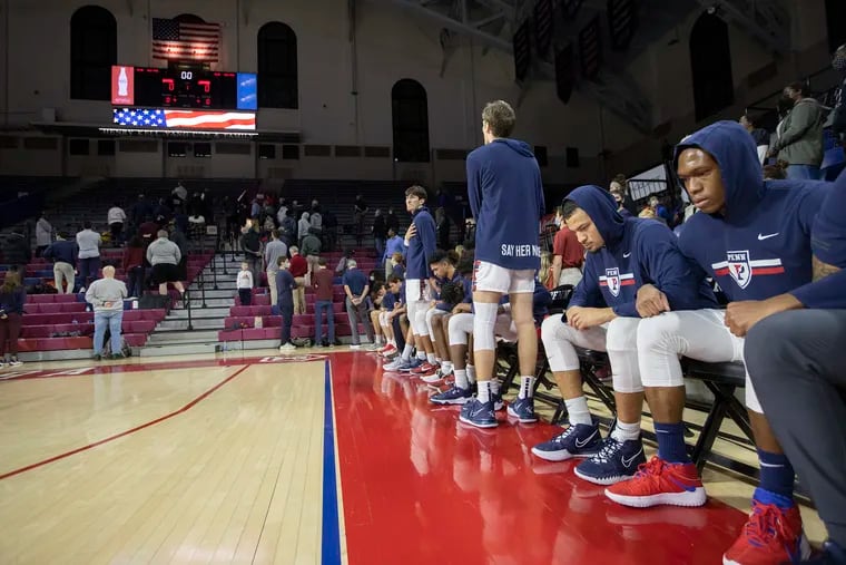 The majority of Penn's team sits for the national anthem before the game against Lafayette.