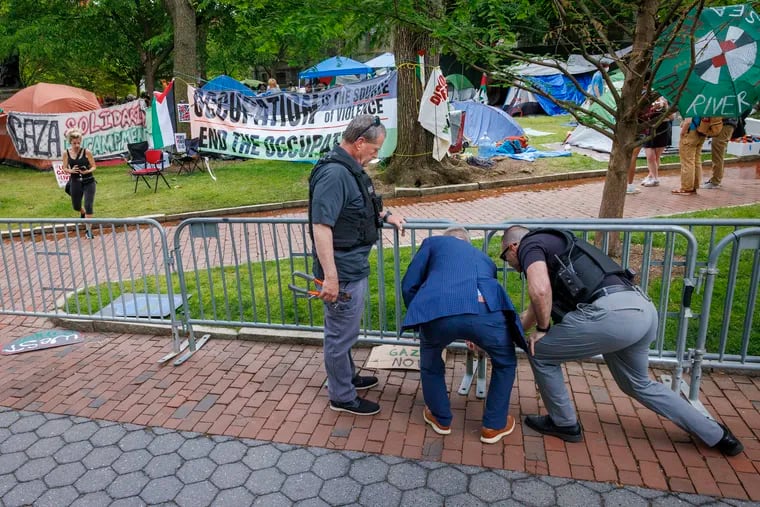 Officers removed wire tires joining barricades together at the Gaza Solidarity Encampment at University of Pennsylvania as seen on Wednesda.