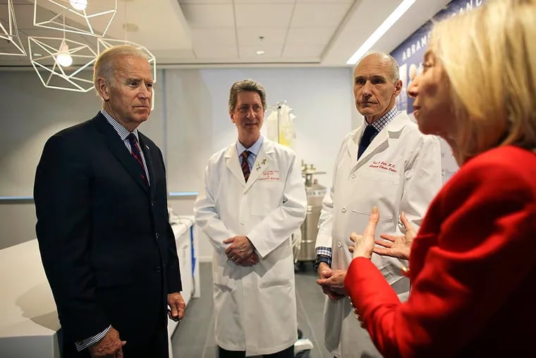 Vice President Joe Biden (left) listens to Dr. Amy Gutmann speak with Bruce L. Levine (center) and Carl H. June in the Abramson Cancer Center at the University of Pennsylvania in Philadelphia.