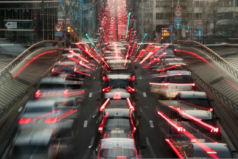 In this slow-shutter zoom effect photo, commuters backed up in traffic during the morning rush hour Wednesday, Dec. 12, 2018, in Brussels, a city that regularly experiences pollution alert warnings.  Predictions from international climate expert, warn that global warming is set to do irreversible environmental damage, with pollutants from burning fossil fuels as one of the main contributors to climate changes. (AP Photo/Francisco Seco)