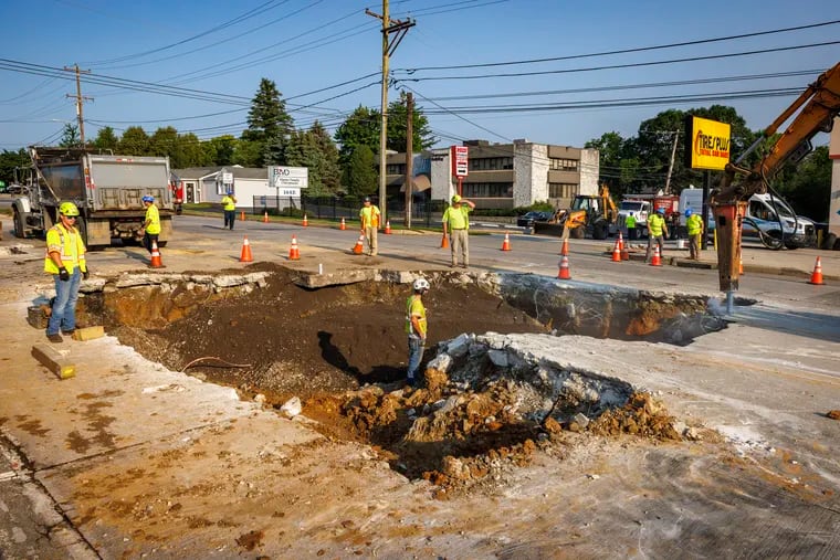 Work crews attend to large sink hole in the middle of Dekalb Pike in front of Tires Plus, 152 E. Dekalb Pike in King of Prussia on Tuesday morning.