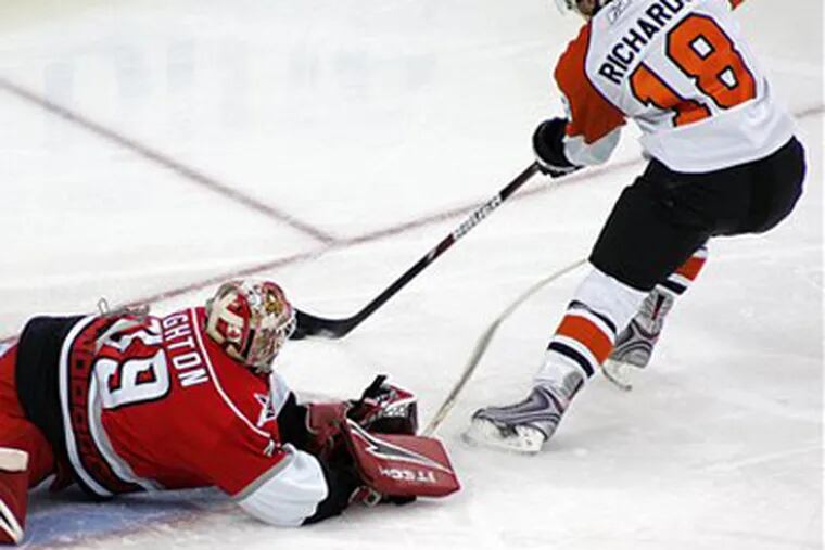 The Flyers' Mike Richards beats Carolina Hurricanes goalie Michael Leighton to score during the first period of Saturday night's game in Raleigh, N.C.. (AP Photo / Karl B DeBlaker)