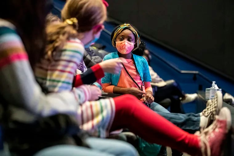 Marea Claybourne-Napier sits with friends before a screening of "The Rainbow Prince," a film she and her parents created, at the County Theater in Doylestown Sunday.