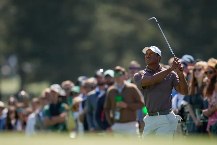 Tiger Woods finished 22nd after Friday's session at the Masters, making the cut for a record 24th consecutive year.