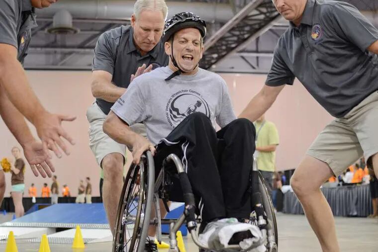 Harold Hack competes in the slalom at the Convention Center, racing past obstacles with help and encouragement.