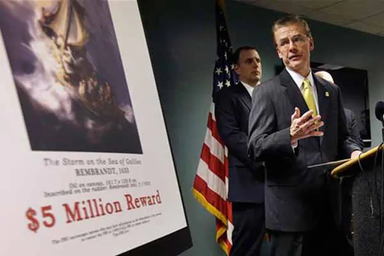 Federal Bureau of Investigation (FBI) Special Agent in Charge Richard DesLauriers, right, stands next to a poster that shows a Rembrandt painting and a reward while facing reporters during a news conference at FBI headquarters in Boston, Monday, March 18, 2013. The FBI believes it knows the identities of the thieves who stole art valued at up to $500 million from Boston's Isabella Stewart Gardner Museum more than two decades ago. DesLauriers says the thieves belong to a criminal organization based in New England and the mid-Atlantic states. (AP Photo/Steven Senne)