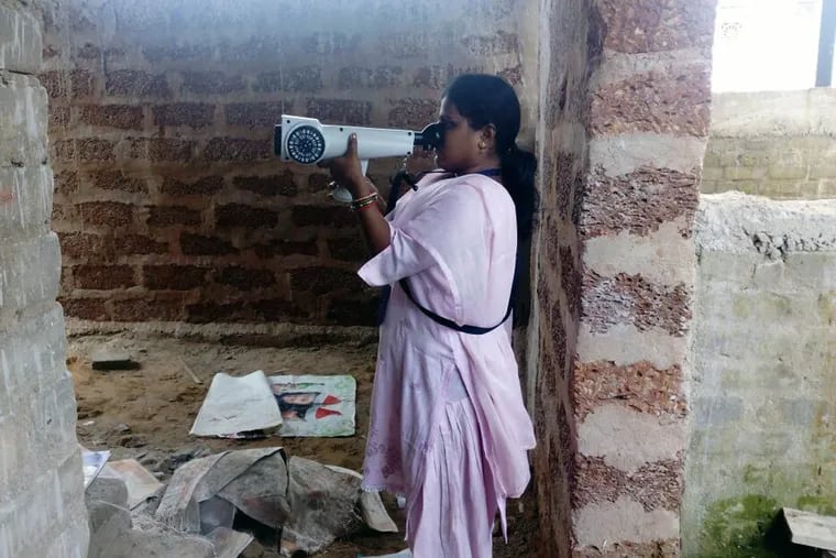 Jayalalita Lenka, a surveyor on the Potty Project team, uses a Nasal Ranger to record the odors in a community toilet under construction in Bhubaneswar, India.
