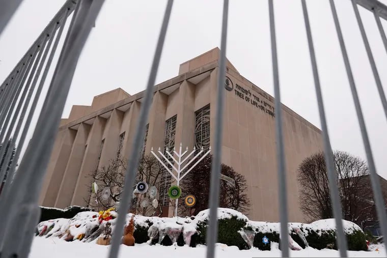 FILE--This file photo from Feb. 11, 2019 shows a temporary barrier around the Tree of Life Synagogue in Pittsburgh where 11 people were killed and seven others injured during an attack on in October of 2018. The synagogue is inviting young people worldwide to submit artwork in an art project called "#HeartsTogether: The Art of Rebuilding." to cover adjacent fencing that surrounds the still-shuttered building. They are looking for "original, uplifting images and graphics" to be printed on windscreens that will cover the temporary perimeter fencing. (AP Photo/Keith Srakocic, File)