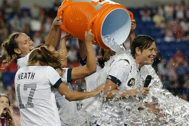 United States' Abby Wambach (right) is showered by teammates after an international friendly soccer match against South Korea at Red Bull Arena, Thursday, June 20, 2013, in Harrison, N.J. The U.S. won 5-0. Wambach is now the greatest goal scorer in international soccer. She scored four goals in the first half to break Mia Hamm's record. (Julio Cortez/AP)