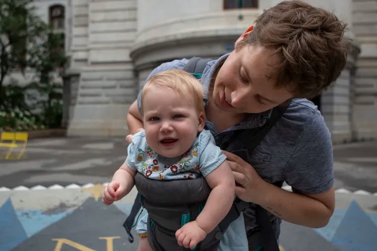 Inquirer opinion and editorial writer Abraham Gutman holds his one-year-old daughter, Mara, in the courtyard of City Hall in Philadelphia on Thursday, June 13, 2019.