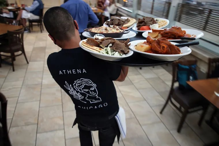 In Chicago's Greektown neighborhood, a worker brings food to diners at the restaurant Athena on Thursday, Oct. 8, 2020. More people are getting jobs but some experts fear a recession could be in the offing. (Terrence Antonio James/Chicago Tribune/TNS)