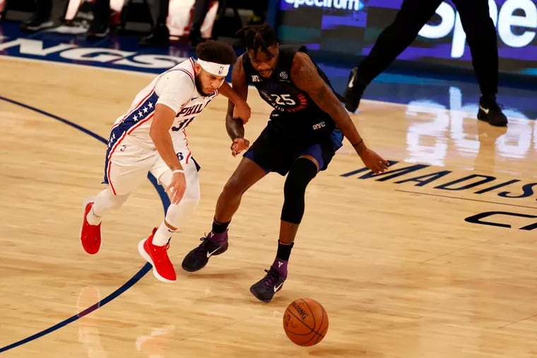 Philadelphia 76ers guard Seth Curry, left, and New York Knicks forward Reggie Bullock, right, chase after a loose ball during the first half of an NBA basketball game Saturday, Dec. 26, 2020, in New York.