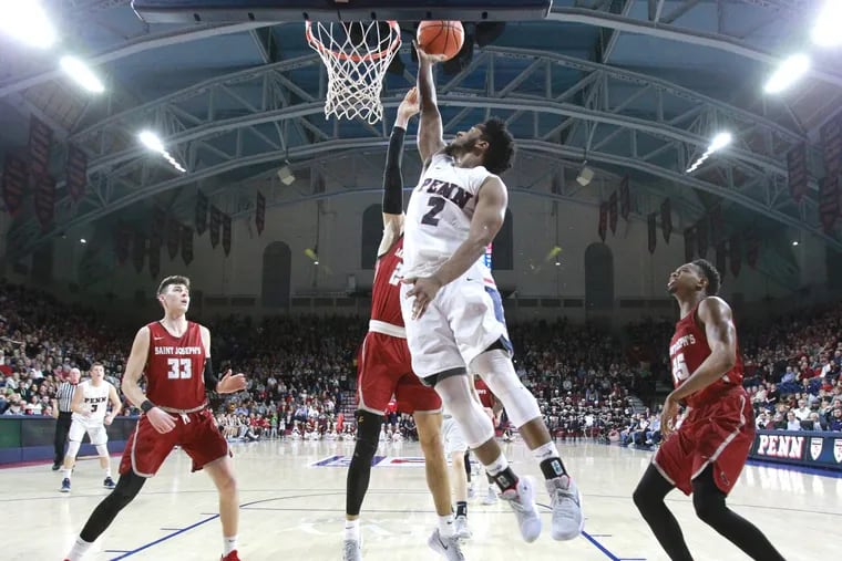 Antonio Woods, center, of Penn goes up for a shot against St. Joseph’s late in the second half at the Palestra on Jan 27, 2018.