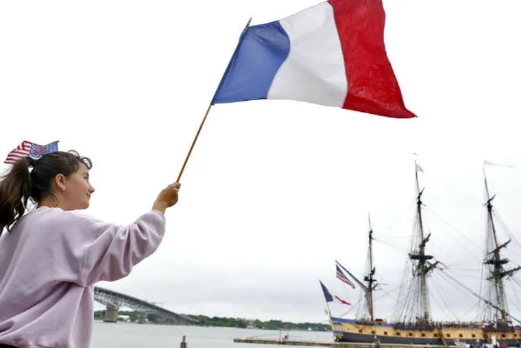 In Yorktown, Va., Nelle Summers , 12, waves a French flag after the tall ship Hermione docked. The ship is expected to draw huge crowds when it sails up the East Coast. (JONATHON GRUENKE / Daily Press)