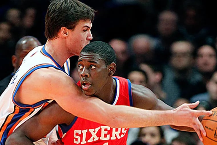 New York Knicks' Danilo Gallinari, left, tries to stop Jrue Holiday late in the first quarter of the Sixers 106-96 win.  (AP Photo/Paul J. Bereswill)