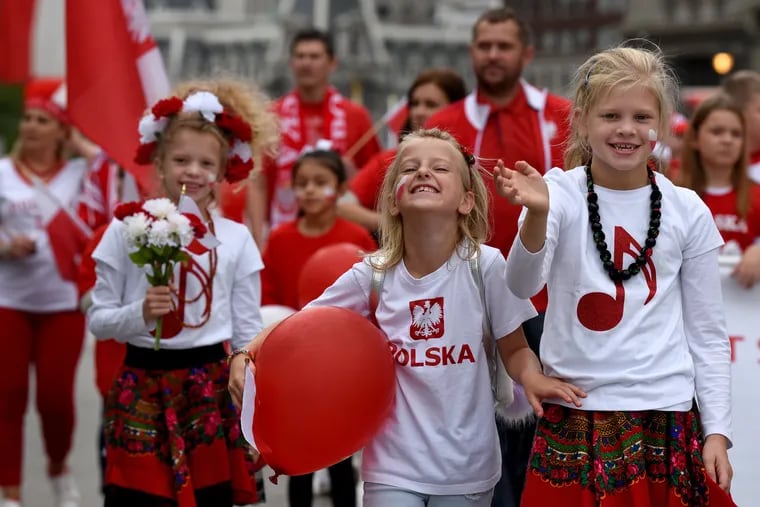 Alicja Iwaniwucz (from left), 7; and sisters Julia Guzdziol, 10 and Emilia Guzdziol, 8, lead their families and classmates from the Polish school at Saint Hedwig church in Trenton, in the 86th annual Pulaski Day Parade on the Ben Franklin Parkway October 6, 2019.