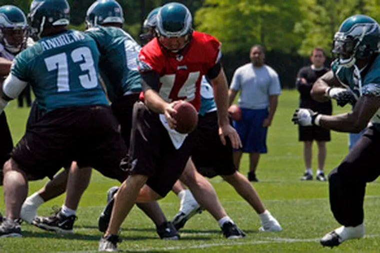 With Shawn Andrews providing protection, quarterback A.J. Feeley prepares to hand off the ball in a drill. Eagles&#0039; minicamp ends today.