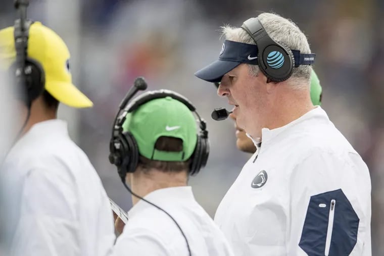Penn State offensive coordinator Joe Moorhead looks at his play list during a 52-0 win against Akron at Beaver Stadium in University Park, Pa., on Saturday, Sept. 2, 2017.