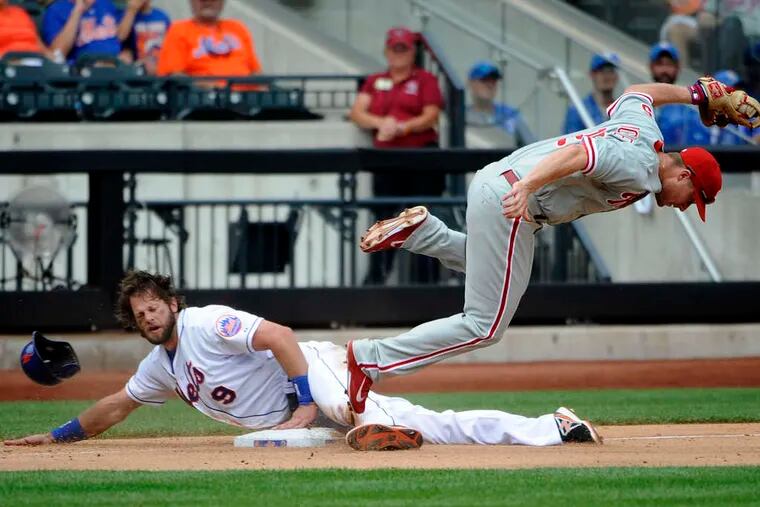 The Mets’ Kirk Nieuwenhuis steals third base as the Phils’ Cody Asche goes flying in the eighth inning. Nieuwenhuis later scored what proved to be the decisive run.