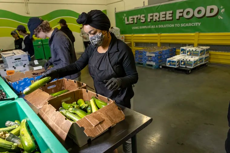 Ellesha Palmer sorts the good from bad donated zucchini at the Philadelphia Wholesale Produce Market for Sharing Excess, a food-rescue organization. Photo taken on July 29, 2022.