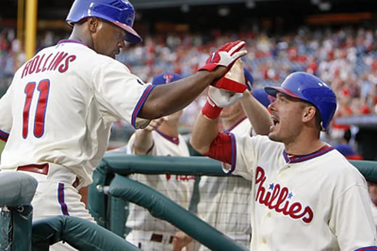 Jimmy Rollins is greeted by Greg Dobbs after scoring the winning run on a wild pitch. (David Maialetti / Staff Photographer)
