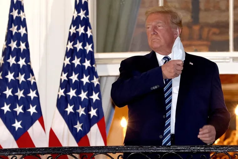 President Donald Trump removes his mask upon returning to the White House from Walter Reed National Military Medical Center Monday. Trump spent three days hospitalized for coronavirus.