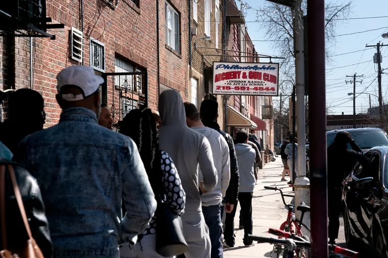 A line of people wait outside of the Philadelphia Gun and Archery Club in South Philadelphia on Wednesday morning. Some customers were looking to purchase firearms, while gun owners wanted to stock up on ammunition.