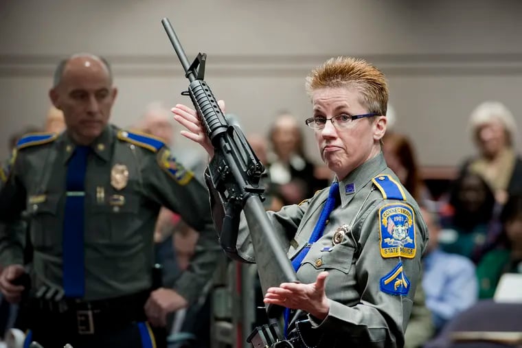 In this 2013 photo, firearms training unit Detective Barbara J. Mattson, of the Connecticut State Police, holds up a Bushmaster AR-15 rifle, the same make and model of gun used by Adam Lanza in the Sandy Hook School shooting, for a demonstration during a hearing of a legislative subcommittee reviewing gun laws, at the Legislative Office Building in Hartford, Conn. The Supreme Court said Tuesday that a survivor and relatives of victims of the Sandy Hook Elementary School shooting can pursue their lawsuit against the maker of the rifle used to kill 26 people.