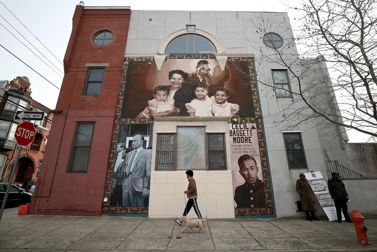 Coby Collins walks his dog, Murphy, by mural of Cecil B. Moore at Jefferson and Bouvier Streets in Philadelphia, PA on February 20, 2020. The mural was vandalized but quickly repaired. .