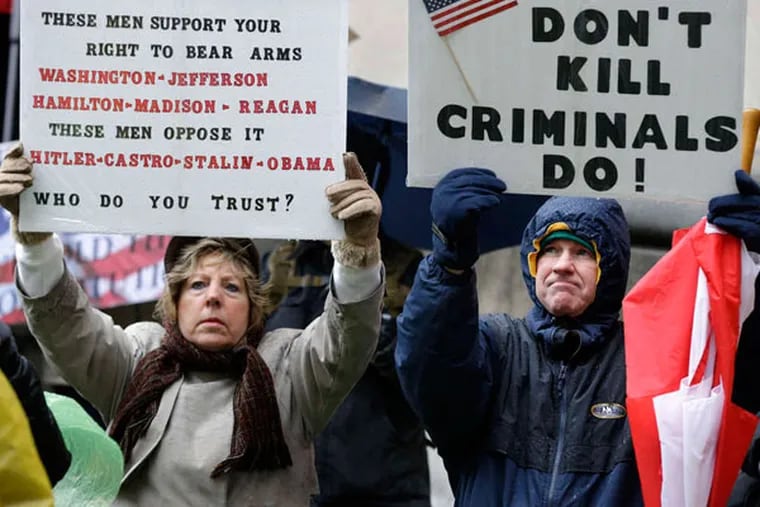 Betty and Robert Bailey of Millstone Township, N.J., hold signs during a Second Amendment rally outside the Statehouse in Trenton in Feb. 2013. (Mel Evans/AP/File)
